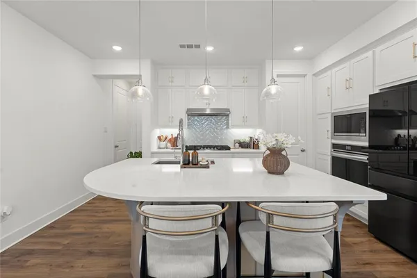 a kitchen with a table chairs stove and refrigerator