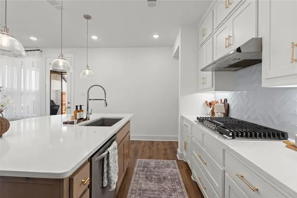 a kitchen with sink a stove and cabinets