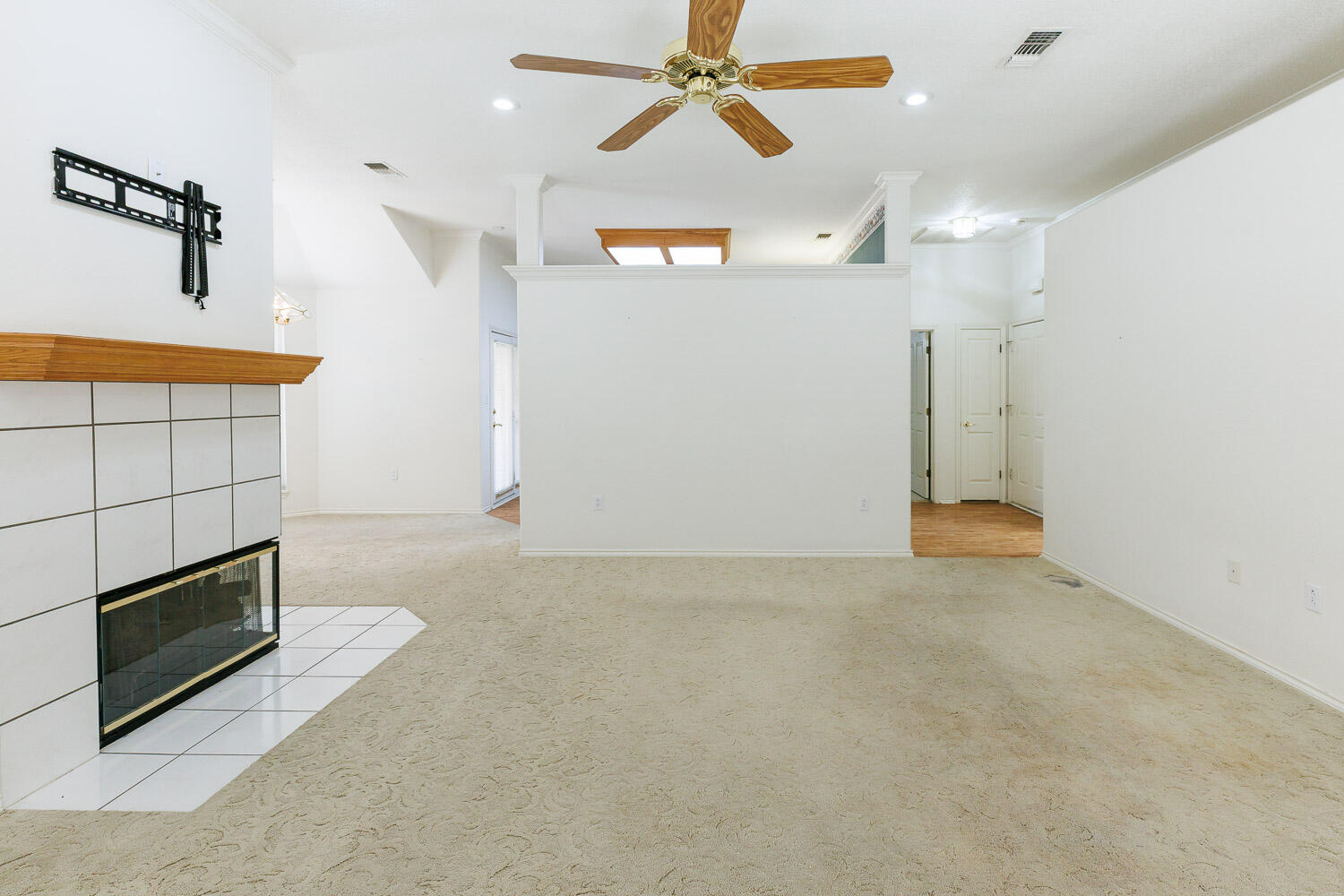 6904 Freeport Avenue Lubbock, TX 79424 - Photo 2 of 49 an empty room with a fireplace and fan