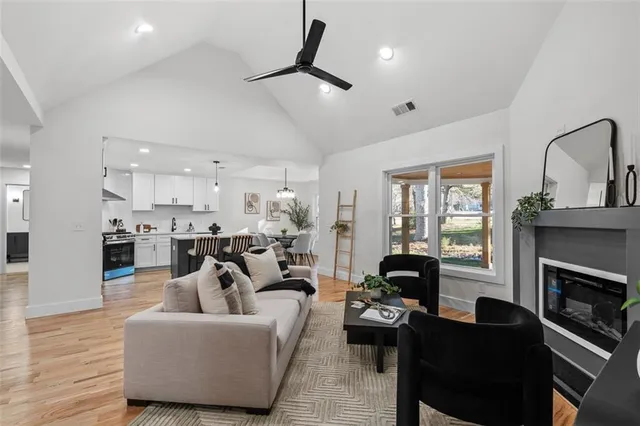 a kitchen with stainless steel appliances a dining table chairs stove and white cabinets