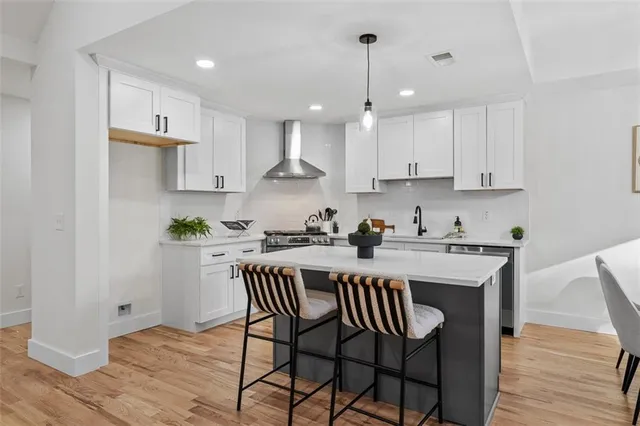 a kitchen with stainless steel appliances a white sink a stove a refrigerator and cabinets