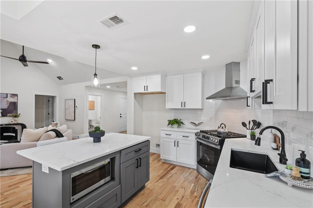 1883 Bennett Ridge Southwest Snellville, GA 30078 - Photo 15 of 56 a kitchen with a sink a stove and cabinets