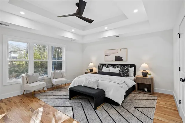 a spacious bedroom with a bed a couch and a chandelier