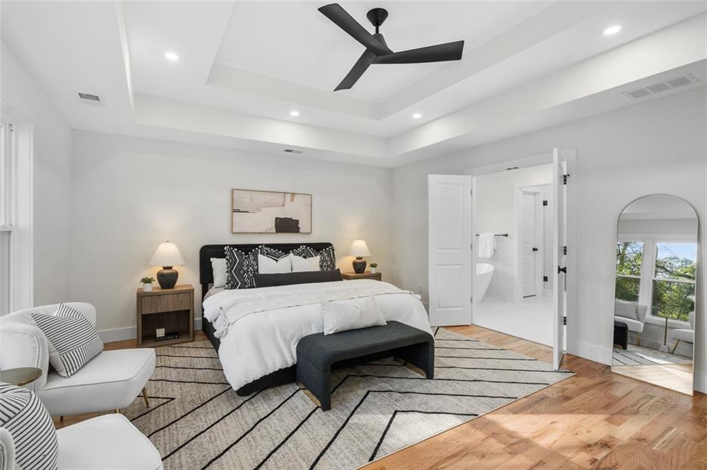 1883 Bennett Ridge Southwest Snellville, GA 30078 - Photo 21 of 56 a spacious bedroom with a bed a couch and a chandelier