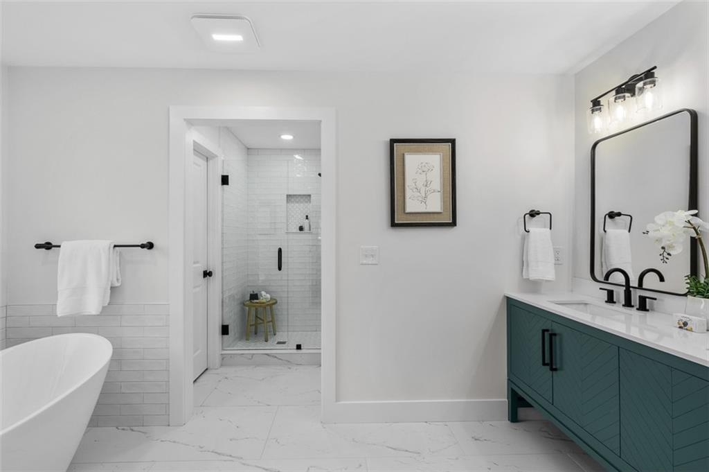 1883 Bennett Ridge Southwest Snellville, GA 30078 - Photo 23 of 56 a bathroom with a tub sink and mirror