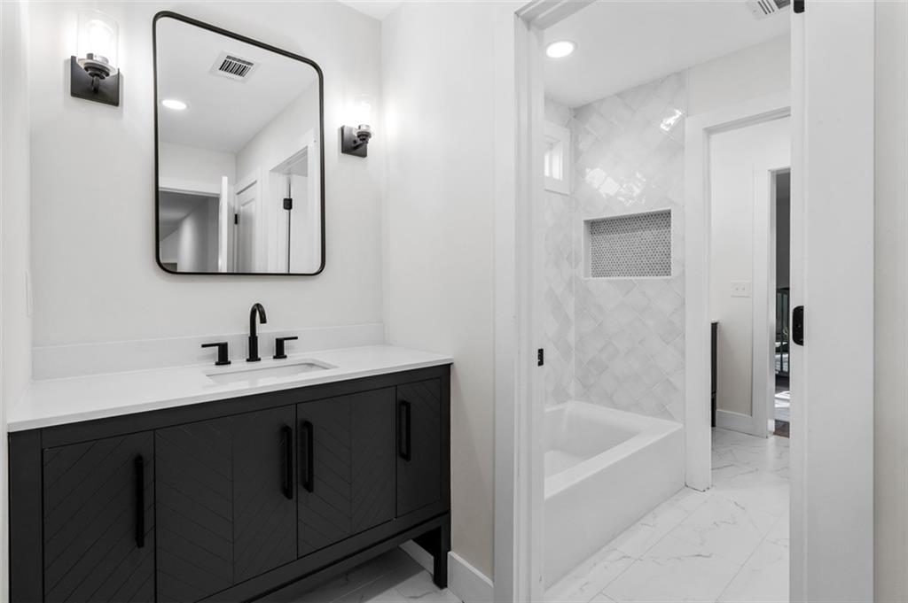 1883 Bennett Ridge Southwest Snellville, GA 30078 - Photo 33 of 56 a bathroom with a bathtub sink vanity and mirror