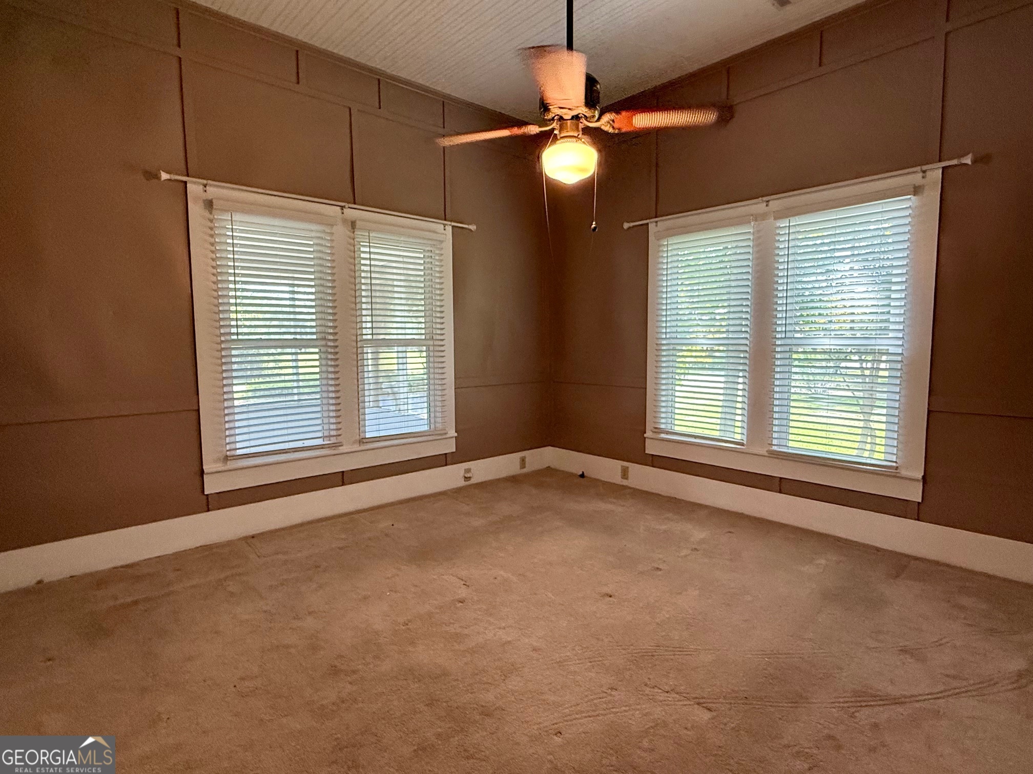 450 South Rountree Street Metter, GA 30439 - Photo 4 of 17 an empty room with window chandelier fan and windows