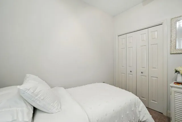 a bedroom with a bed and a white wall