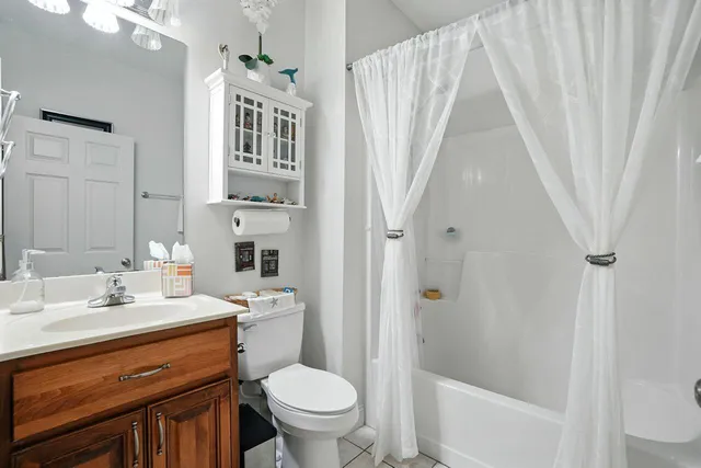 a bathroom with a sink a toilet and a large mirror