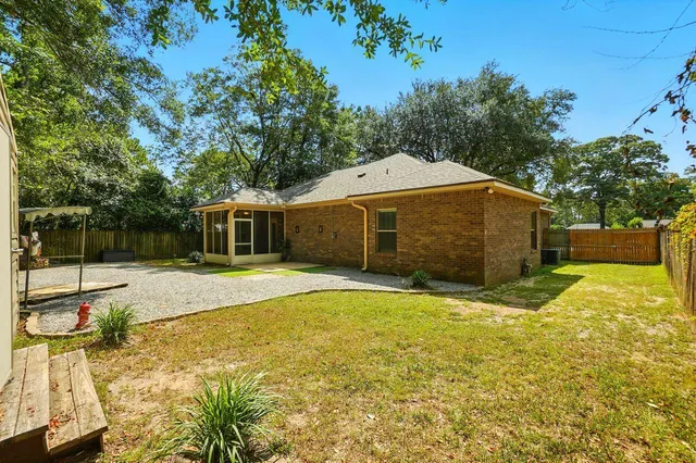 a view of backyard with barbeque grill and wooden fence