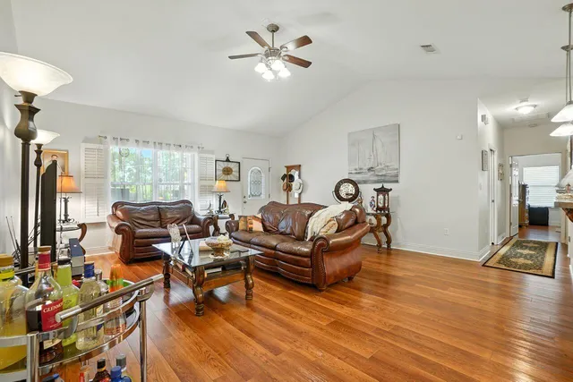 a living room with furniture a flat screen tv and a table