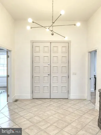 a spacious bedroom with a bed and a chandelier