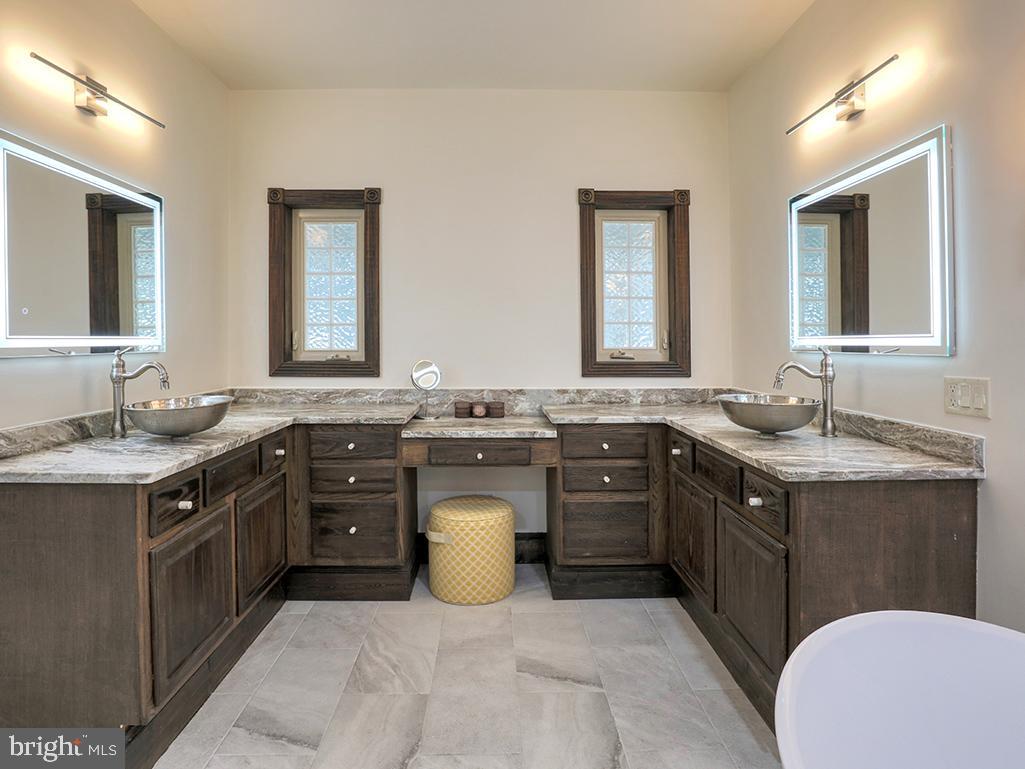 6 Cinderberry Court Georgetown, DE 19947 - Photo 45 of 117 a spacious bathroom with a granite countertop double vanity and a mirror