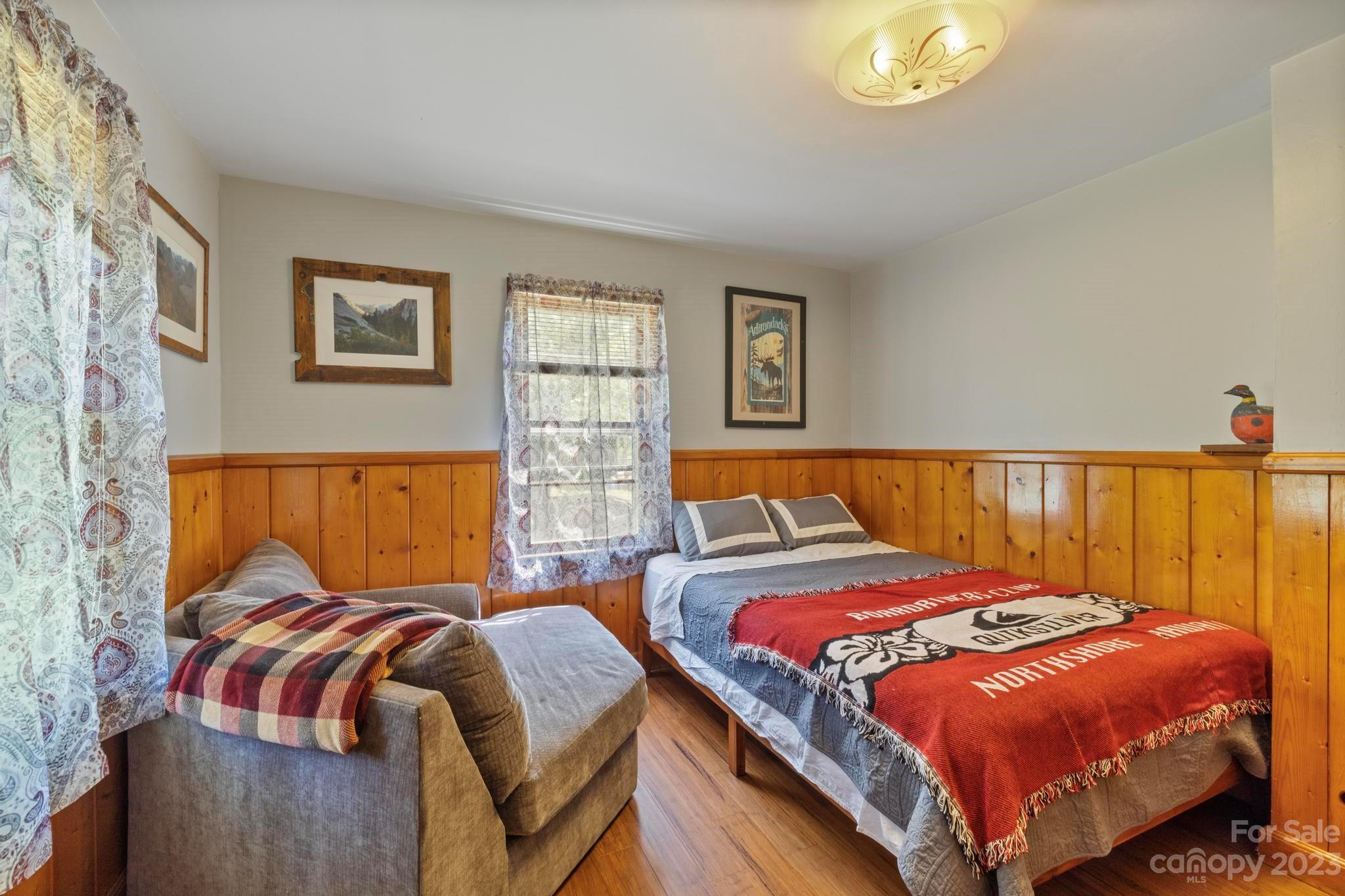 500 Indian Springs Road Clyde, NC 28721 - Photo 12 of 36 a bedroom with a bed and a lamp with the wooden floor