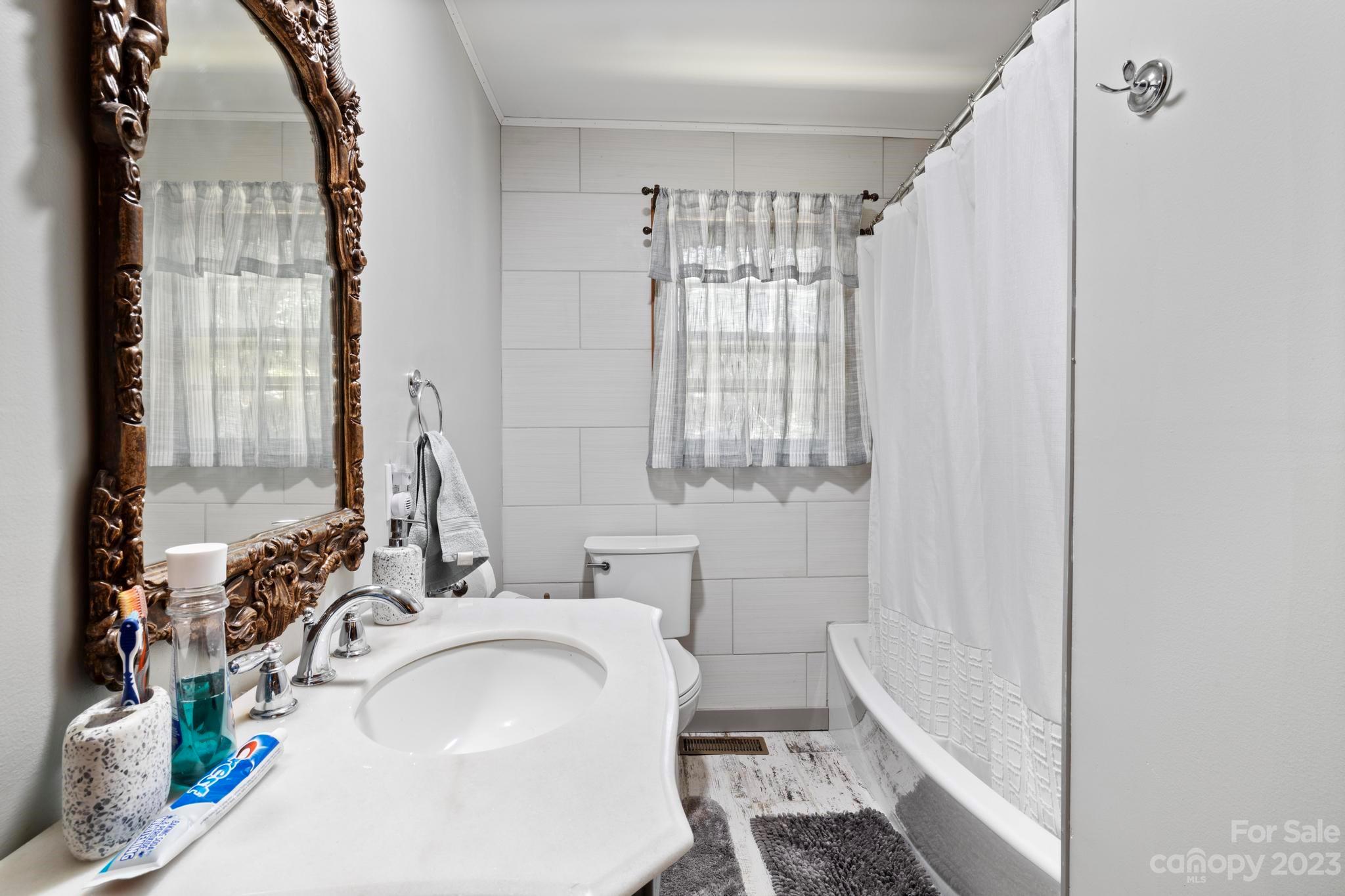 500 Indian Springs Road Clyde, NC 28721 - Photo 14 of 36 a bathroom with a sink a toilet and tub
