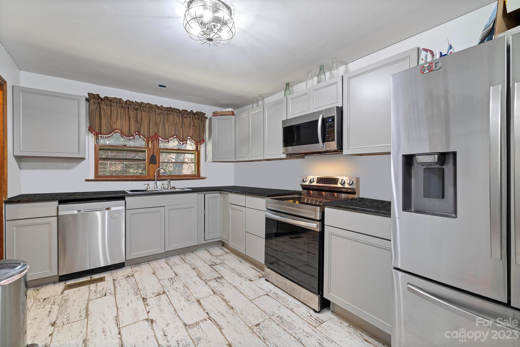 500 Indian Springs Road Clyde, NC 28721 - Photo 2 of 36 a kitchen with granite countertop a stove a sink and a microwave