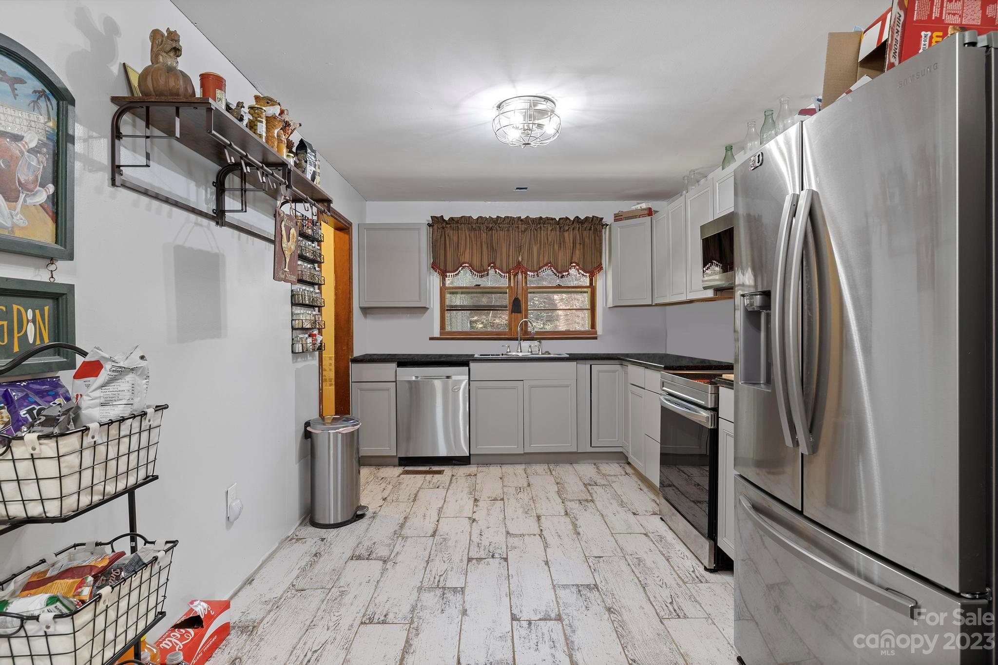500 Indian Springs Road Clyde, NC 28721 - Photo 3 of 36 a kitchen with granite countertop a refrigerator and a sink