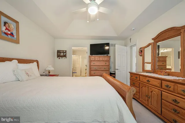 a spacious bedroom with a bed and a flat screen tv