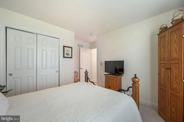 a bedroom with a bed and a flat tv screen on wall