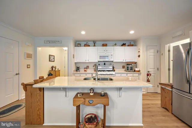 a kitchen with kitchen island a sink stove and refrigerator