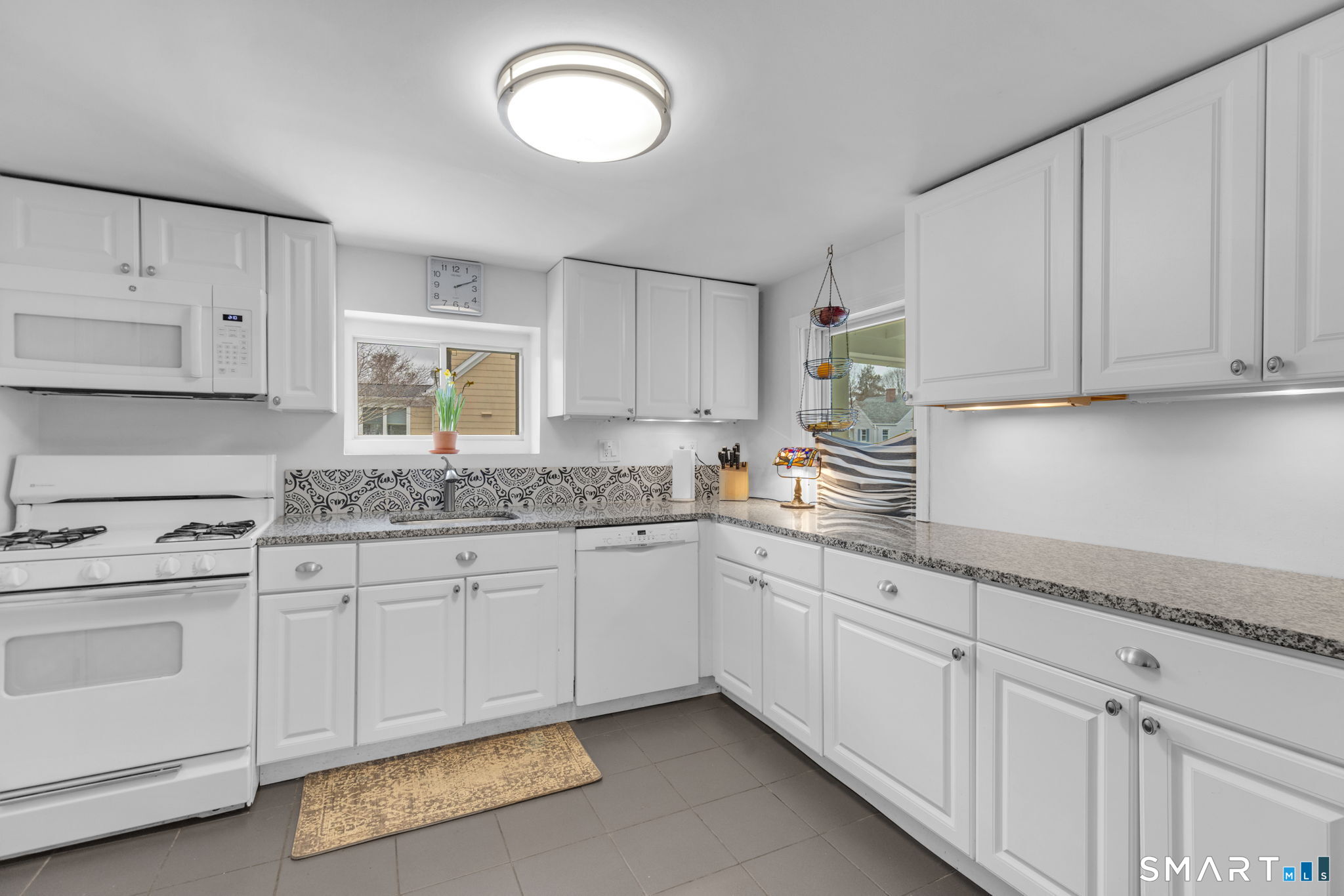 510 Reef Road Fairfield, CT 06824 - Photo 11 of 31 a kitchen with granite countertop white cabinets and white appliances