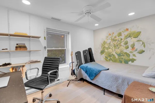 a bedroom with furniture and a wooden floor