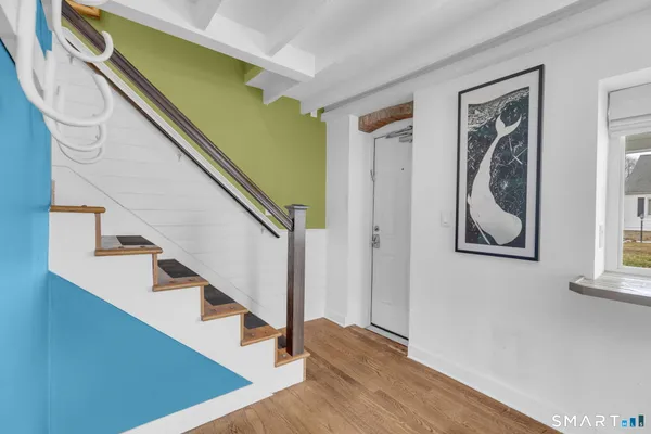a view of front door with wooden floor and stairs