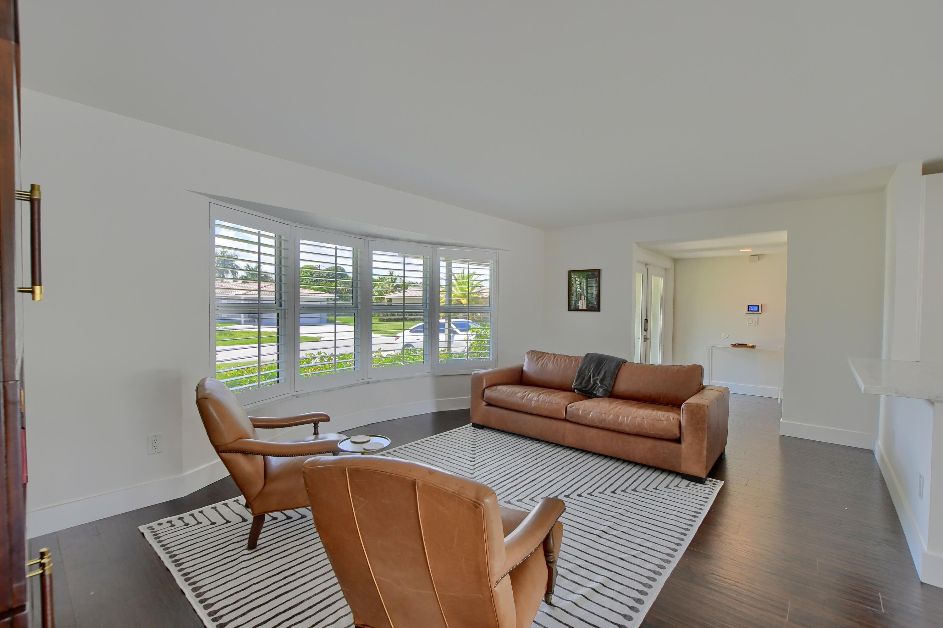 1167 Southwest 13th Drive Boca Raton, FL 33486 - Photo 2 of 41 a living room with furniture a rug and a large window