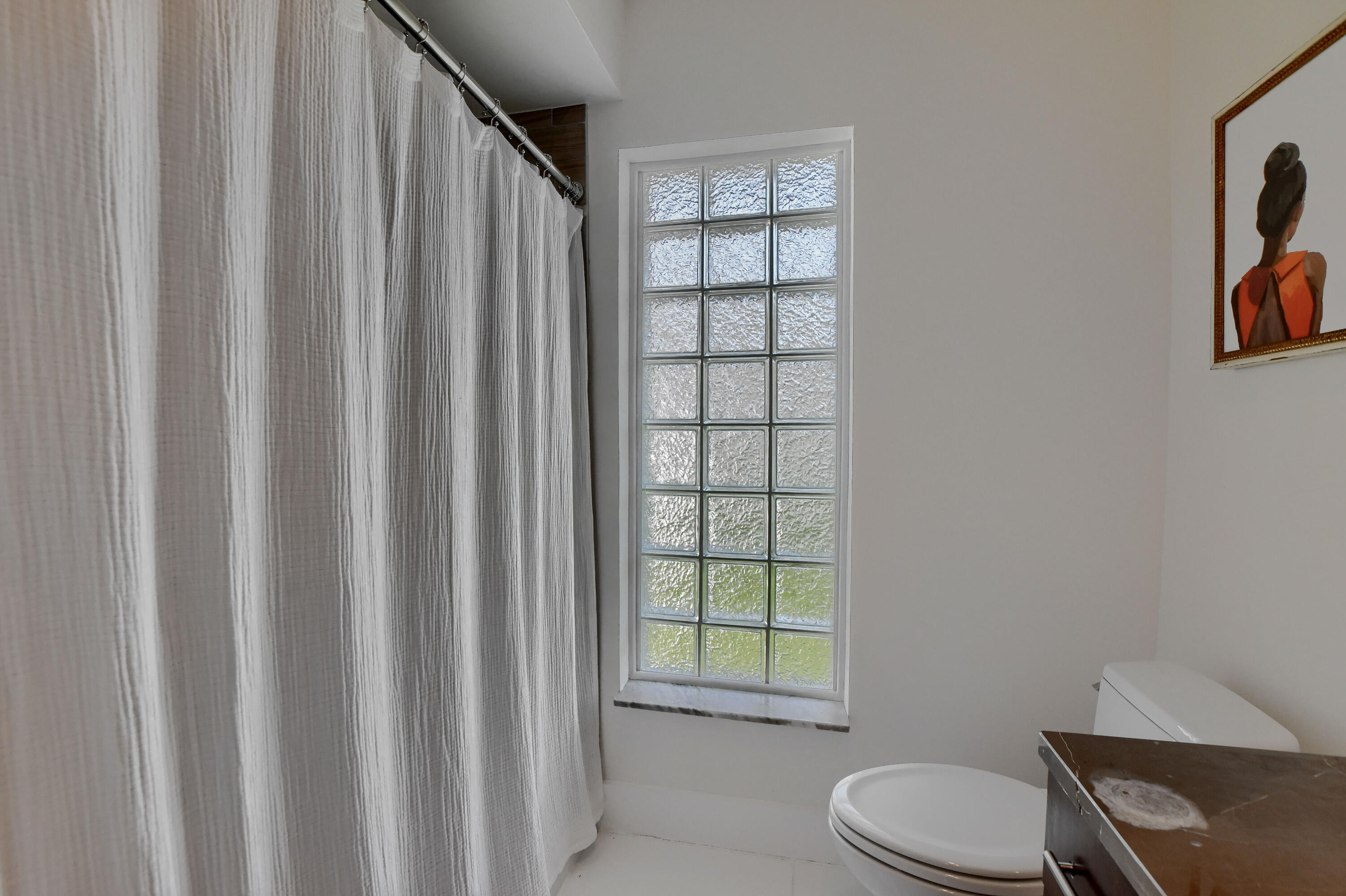 1167 Southwest 13th Drive Boca Raton, FL 33486 - Photo 22 of 41 a bathroom with a toilet a sink and a window
