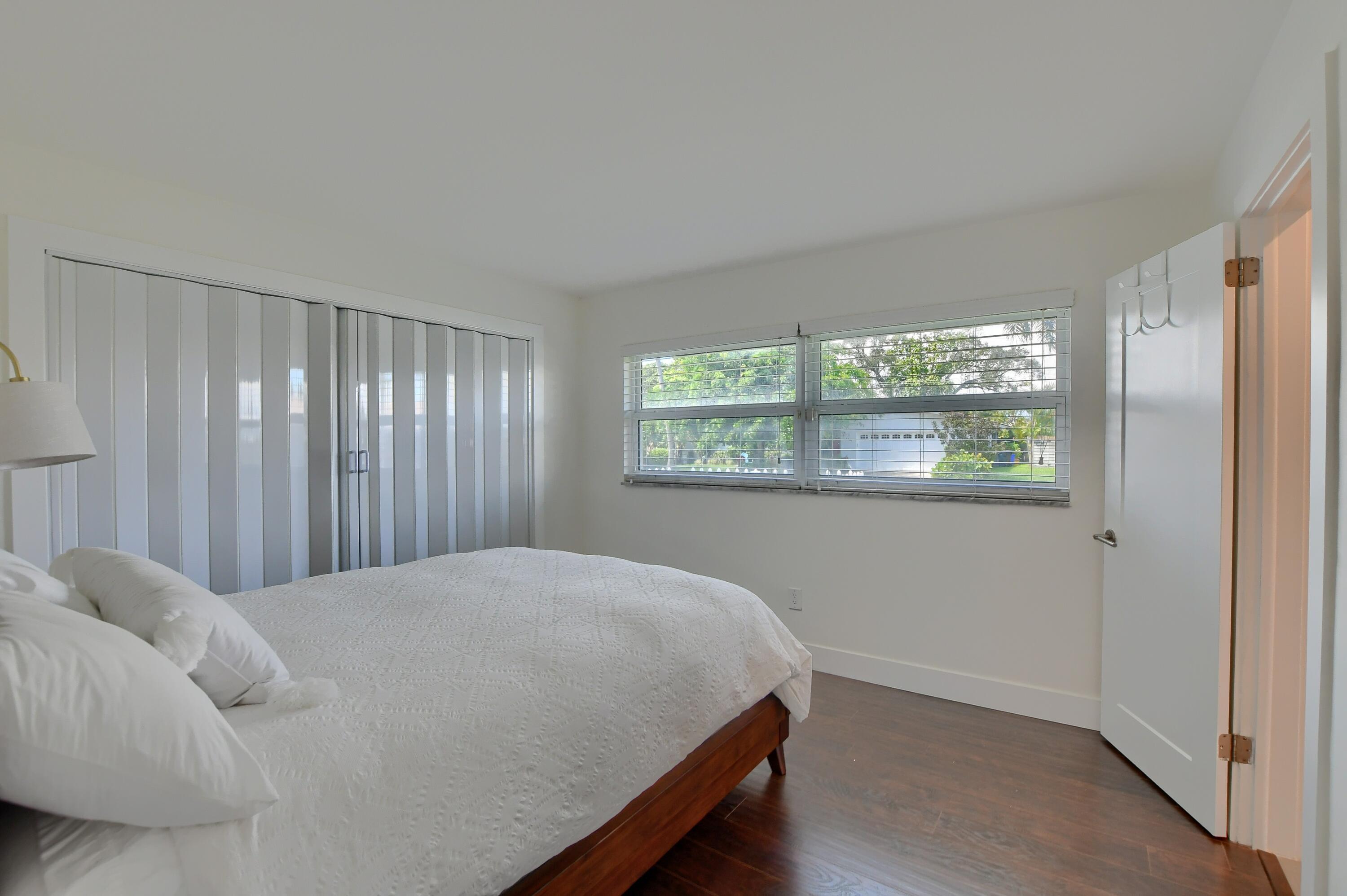 1167 Southwest 13th Drive Boca Raton, FL 33486 - Photo 27 of 41 a bed sitting in a bedroom next to a window