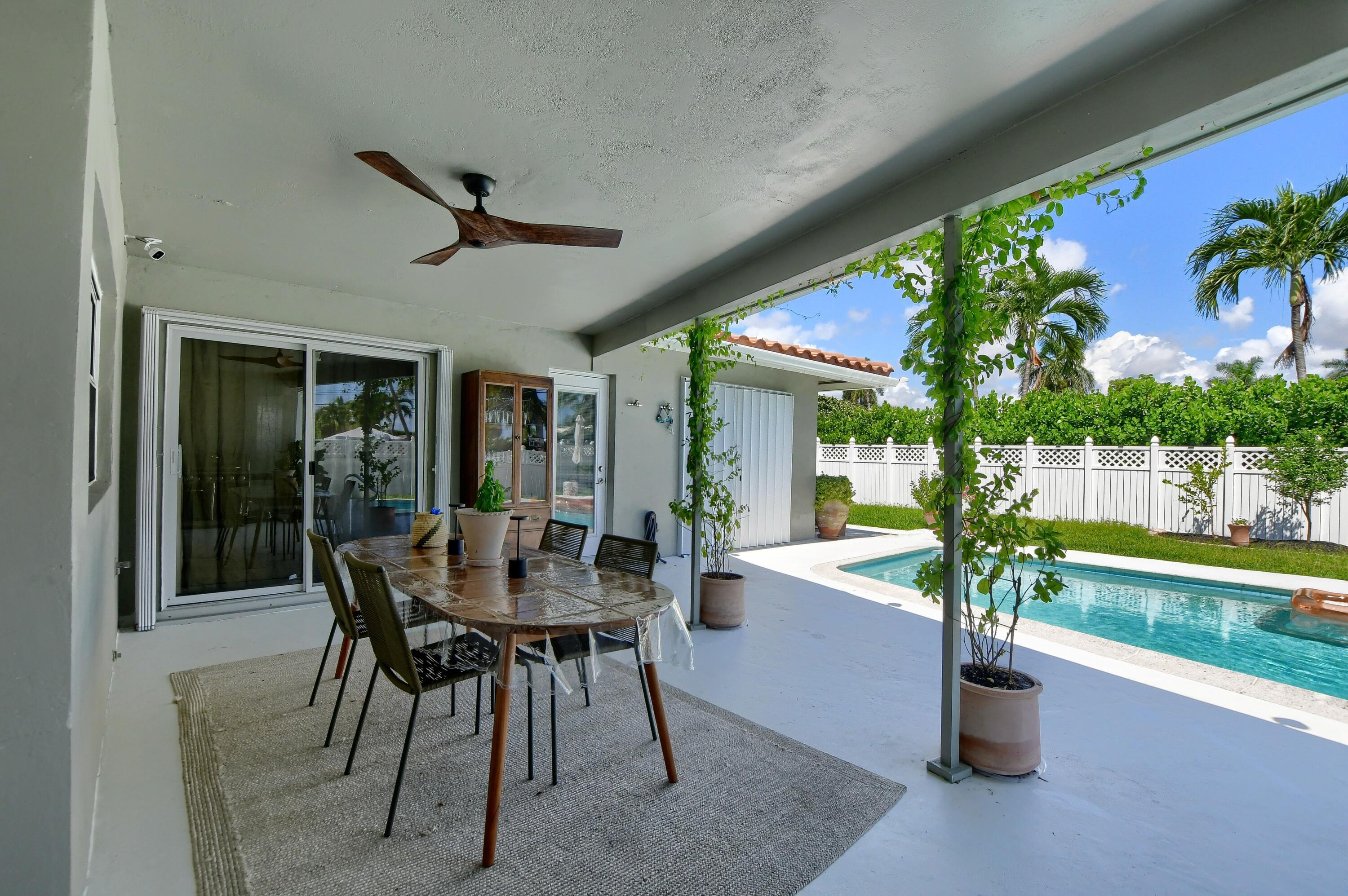 1167 Southwest 13th Drive Boca Raton, FL 33486 - Photo 34 of 41 a dining room with furniture potted plants and wooden floor