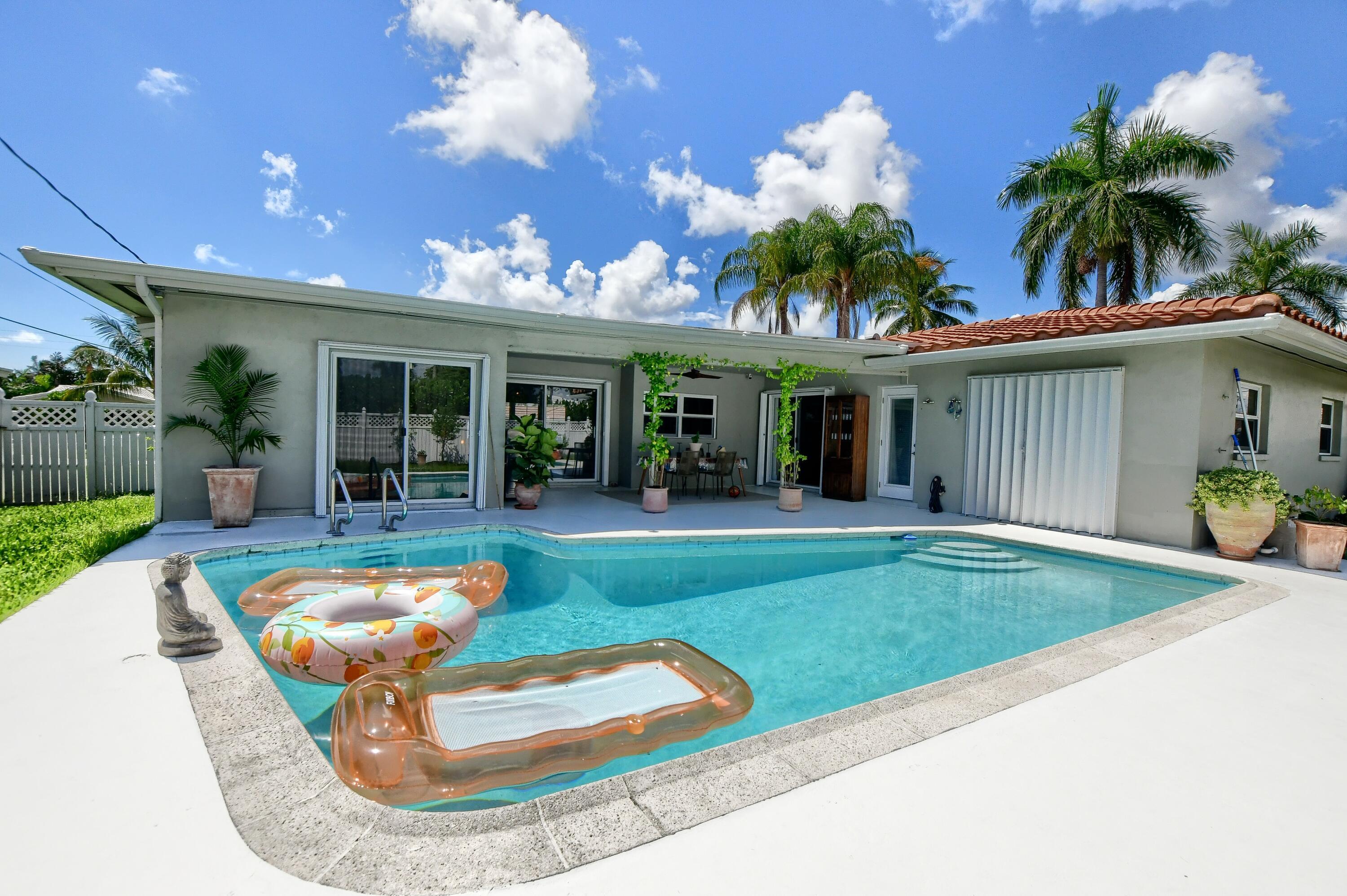 1167 Southwest 13th Drive Boca Raton, FL 33486 - Photo 36 of 41 a view of a house with swimming pool and a yard