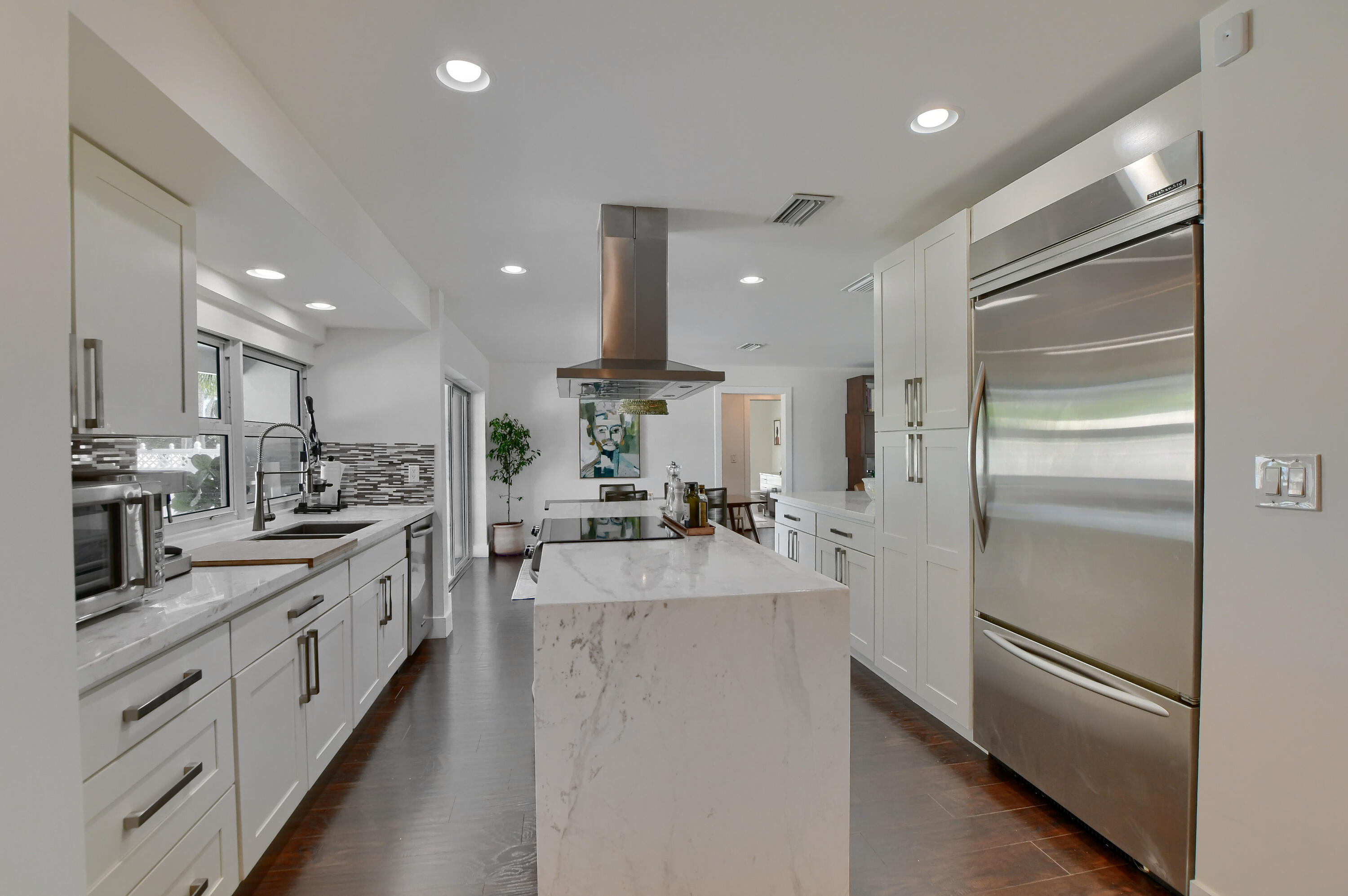 1167 Southwest 13th Drive Boca Raton, FL 33486 - Photo 9 of 41 a large kitchen with stainless steel appliances kitchen island a large counter top and a refrigerator