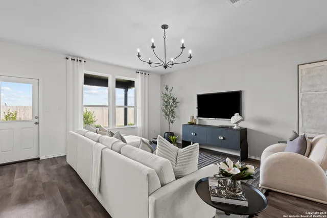 a living room with furniture a flat screen tv and a window