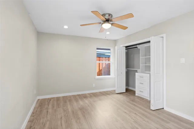 an empty room with closet and windows