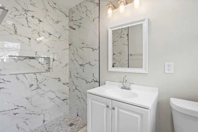 a bathroom with a sink a toilet and mirror