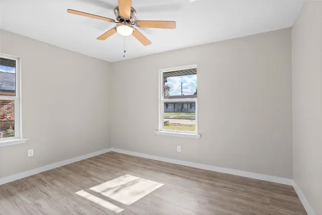 an empty room with a window and a ceiling fan
