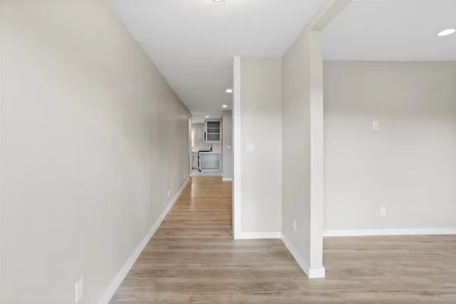 a hallway with wooden floor and entryway