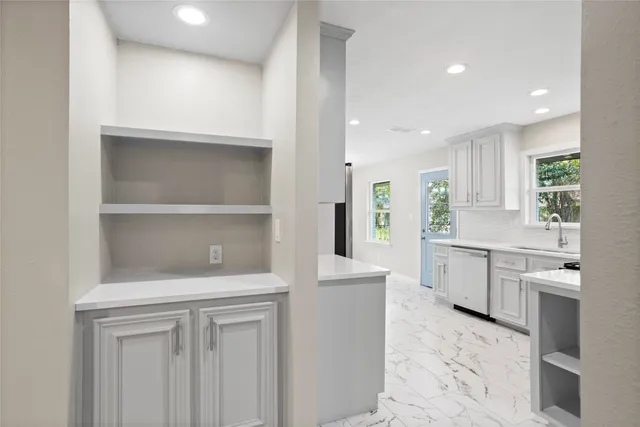 a kitchen with white cabinets and sink