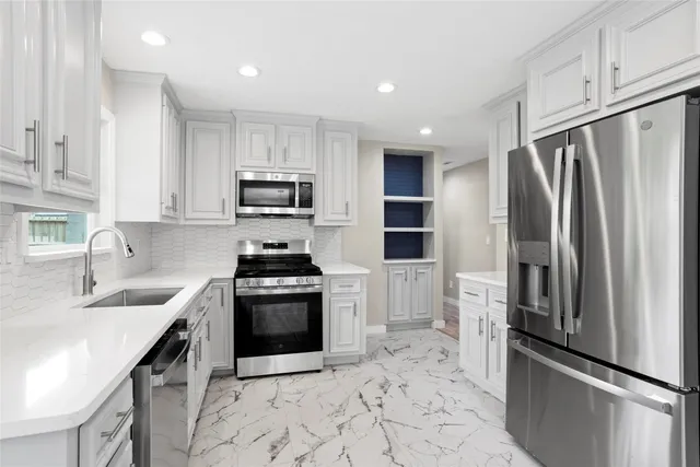 a kitchen with stainless steel appliances granite countertop a refrigerator sink and stove