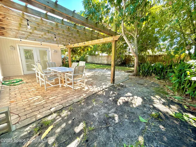 a view of a patio with table and chairs and floor to ceiling window