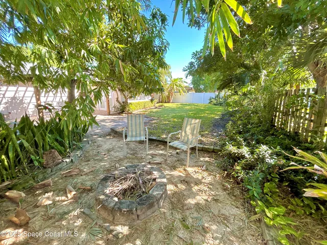 a view of a yard with plants and trees