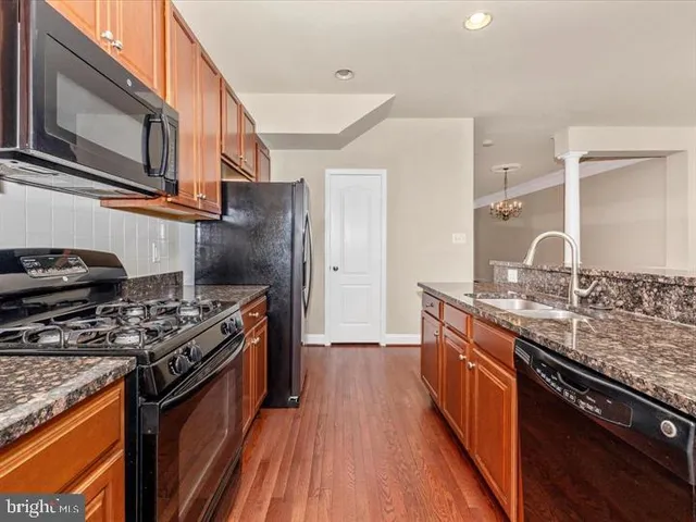 a kitchen with stainless steel appliances granite countertop a stove a sink dishwasher and a refrigerator