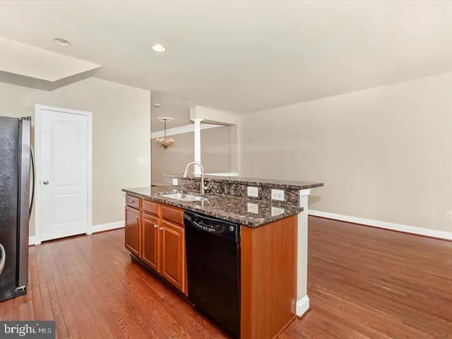 a kitchen with stainless steel appliances granite countertop a stove and wooden floor