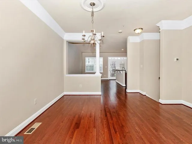 a view of a big room with wooden floor and a kitchen
