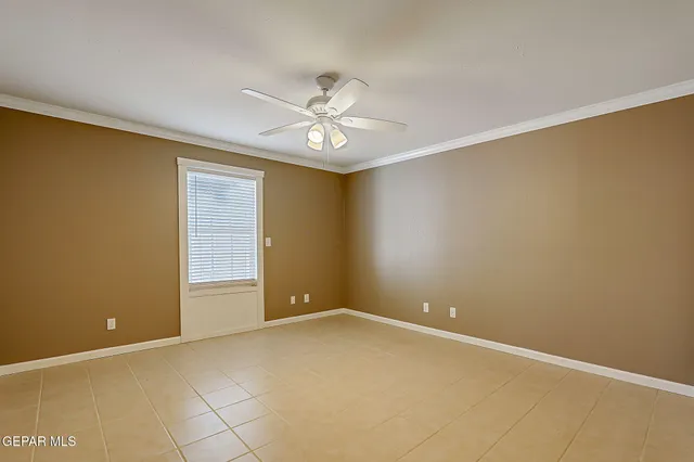 an empty room with a ceiling fan and a window