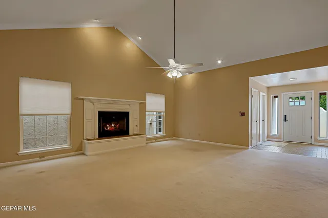 an empty room with windows and fireplace