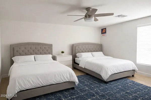 a large bed sitting in a bedroom next to a window