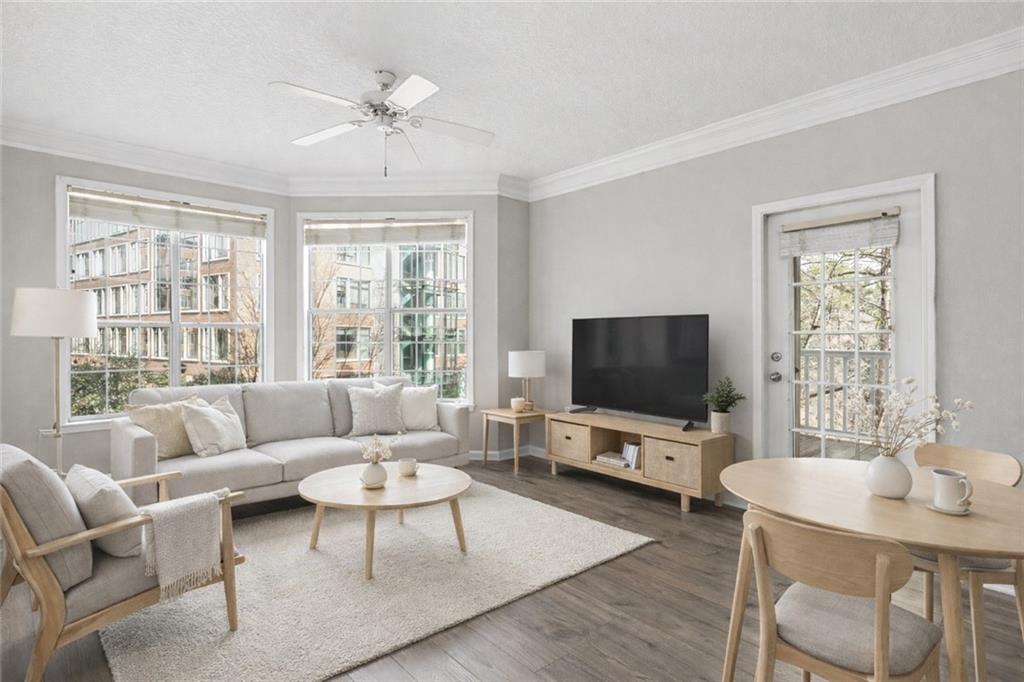 a living room with furniture a flat screen tv and a large window