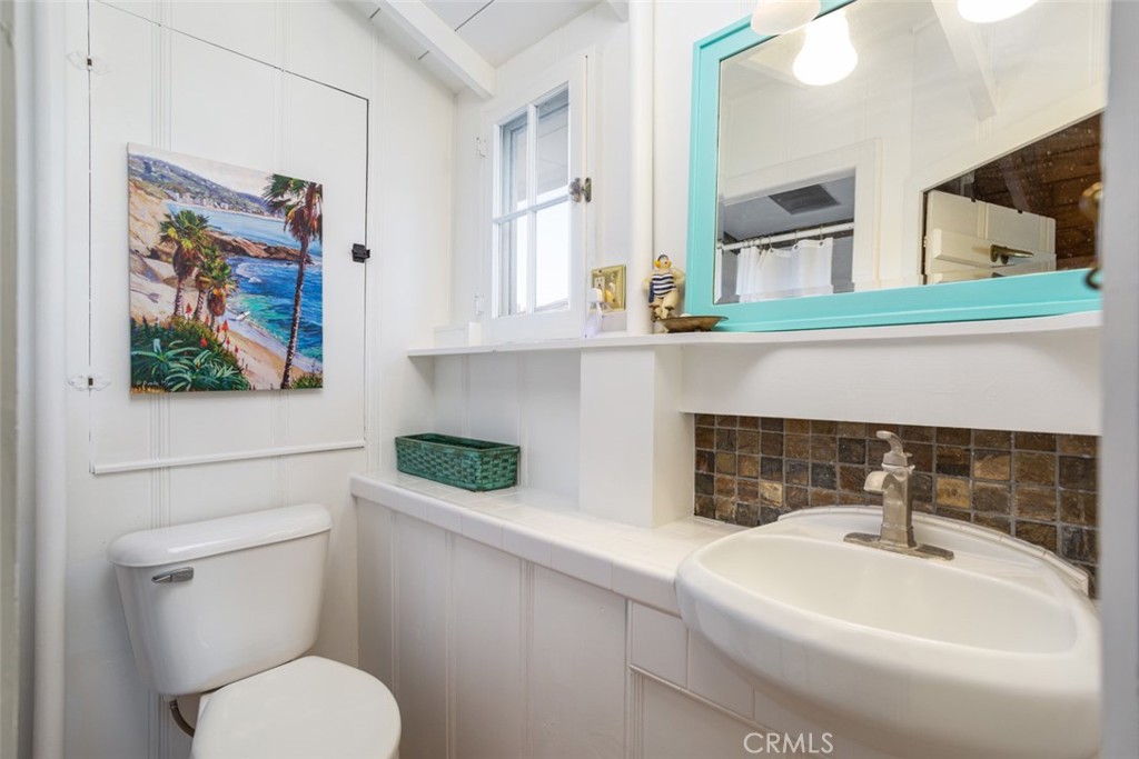 856 Cliff Drive Laguna Beach, CA 92651 - Photo 19 of 28 a bathroom with a toilet a sink and mirror